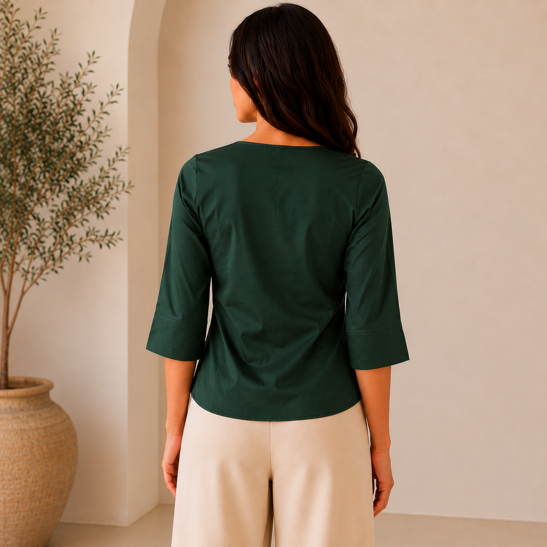 Woman wearing a green blouse with a collar indoors