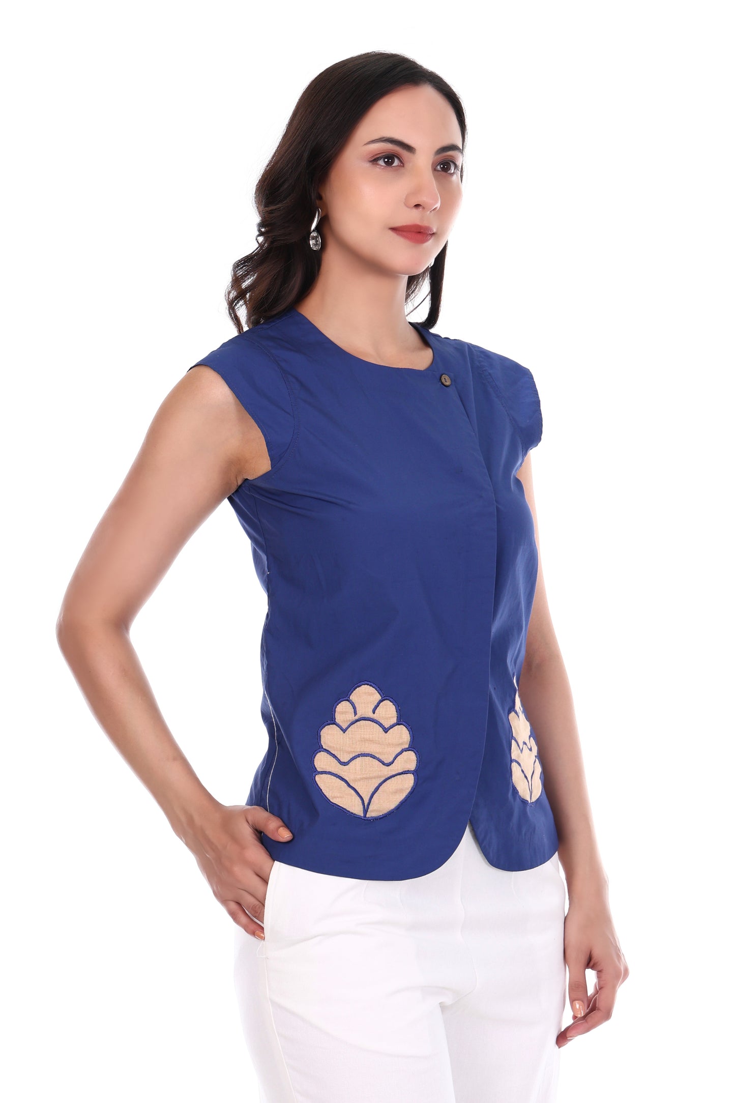 Woman wearing a blue top with beige floral patterns on a white background