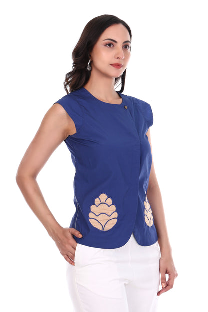 Woman wearing a blue top with beige floral patterns on a white background