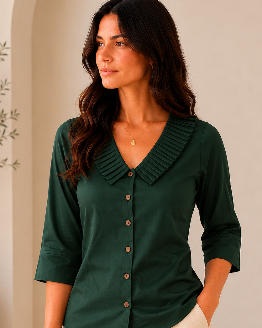 Woman wearing a green blouse with a collar indoors