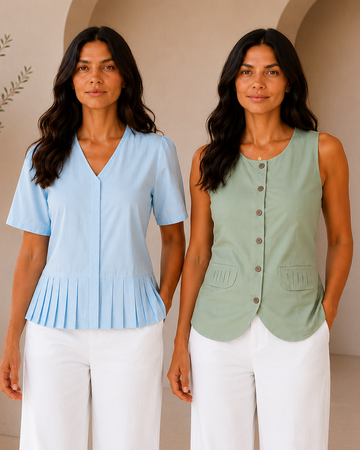 Two women modeling sleeveless tops in a bright, minimalist interior. The woman on the left wears a light blue short-sleeve pleated top with white pants, and the woman on the right wears a sage green sleeveless button-front top with white pants.